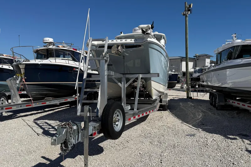 Slide: The Image of 2023 World Cat 280 DC-X boat on trailer in a marina under clear blue sky. - 33