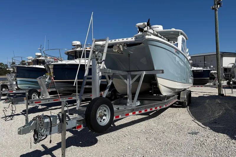 Slide: The Image of 2023 World Cat 280 DC-X boat on trailer in marina under clear blue sky. - 34