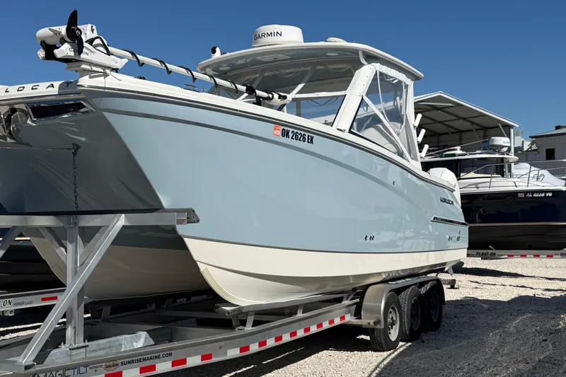 Slide: The Image of 2023 World Cat 280 DC-X boat on trailer, displayed outdoors under clear blue sky. - 35