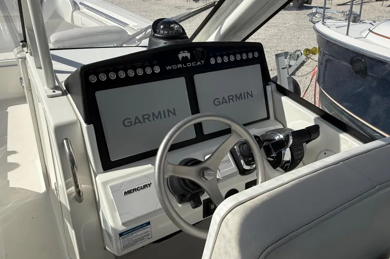 Slide: The Image of 2023 World Cat 280 DC-X boat helm with Garmin displays and Mercury controls. - 43