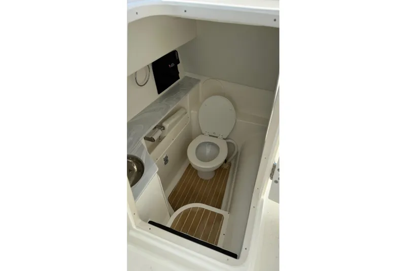 Slide: The Image of 2023 World Cat 280 DC-X boat interior bathroom with toilet and sink. - 57
