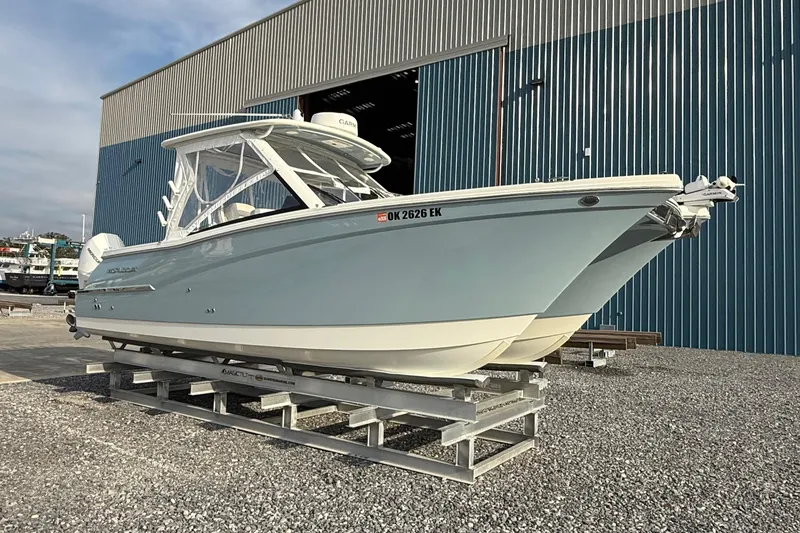 Slide: The Image of 2023 World Cat 280 DC-X boat on display outside a large blue warehouse. - 6