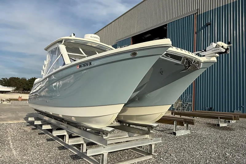 Slide: The Image of 2023 World Cat 280 DC-X boat on display outside a large blue warehouse. - 7