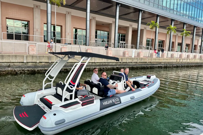 Slide: The Image of 2026 Highfield 660 Velox boat with passengers cruising near a waterfront building. - 3