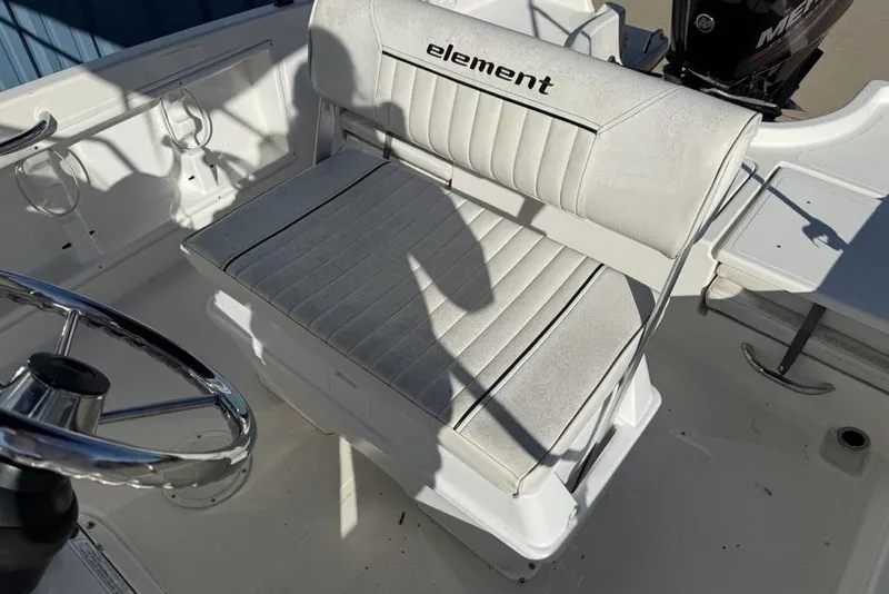 Slide: The Image of 2019 Bayliner Element E18 boat interior with steering wheel and cushioned seating. - 16