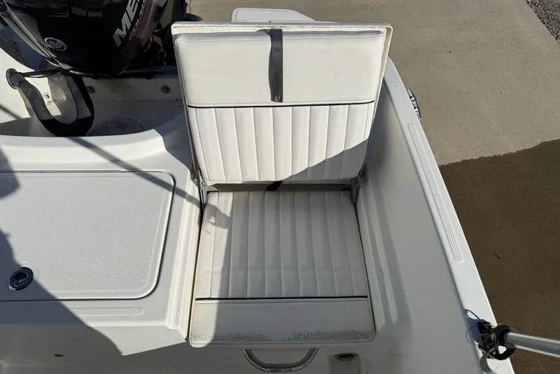 Slide: The Image of 2019 Bayliner Element E18 boat seat with white upholstery and adjacent motor. - 26