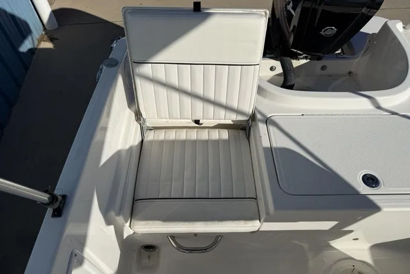 Slide: The Image of 2019 Bayliner Element E18 boat seat with white upholstery and adjacent storage area. - 27