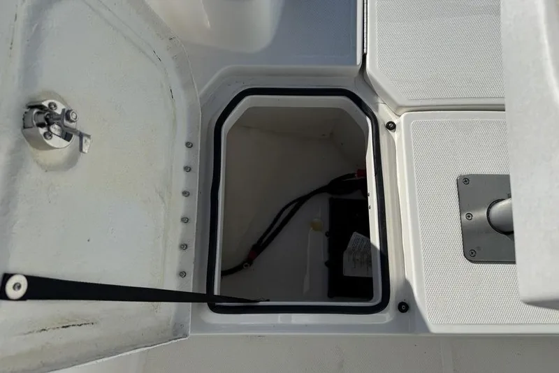 Slide: The Image of 2019 Bayliner Element E18 storage compartment with open hatch and visible battery cables. - 8