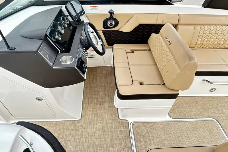 Slide: The Image of 2018 Sea Ray SDX 270 boat interior with beige seating and modern dashboard. - 10