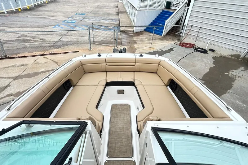 Slide: The Image of 2018 Sea Ray SDX 270 boat with spacious tan seating at dockside. - 12