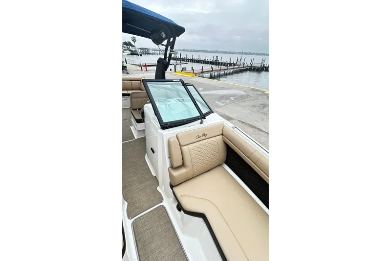 Slide: The Image of 2018 Sea Ray SDX 270 boat interior with tan seating, dockside view. - 14