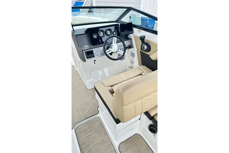 Slide: The Image of 2018 Sea Ray SDX 270 boat interior with beige seating and modern dashboard controls. - 15