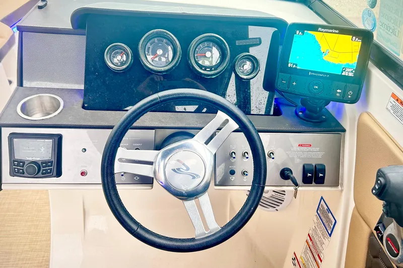 Slide: The Image of 2018 Sea Ray SDX 270 dashboard with steering wheel, gauges, and navigation system. - 16