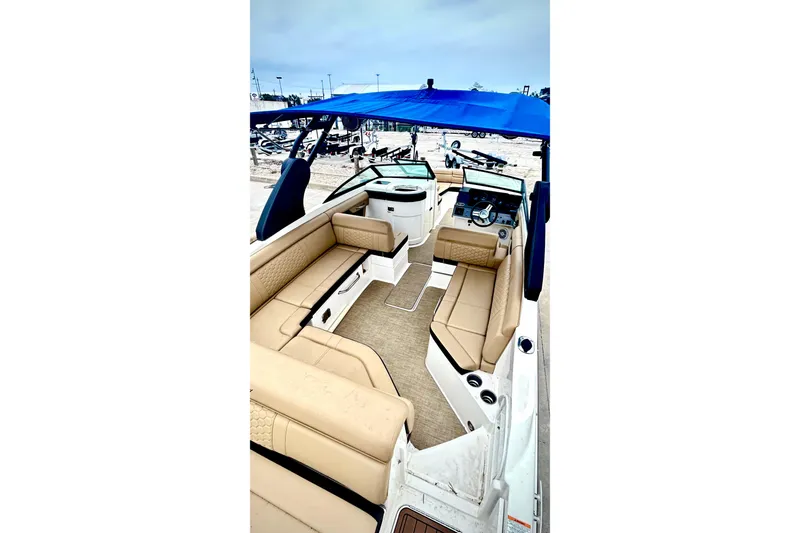 Slide: The Image of 2018 Sea Ray SDX 270 boat interior with beige seating and blue canopy. - 2