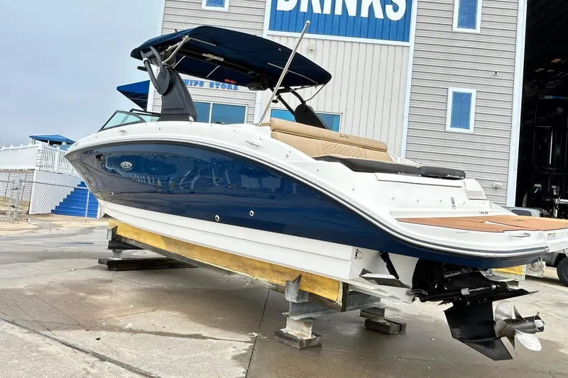 Slide: The Image of 2018 Sea Ray SDX 270 boat on dry dock, blue and white hull, near a building. - 37