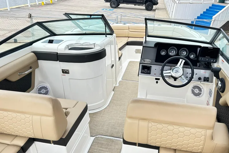 Slide: The Image of 2018 Sea Ray SDX 270 boat interior with beige seating and modern dashboard. - 4