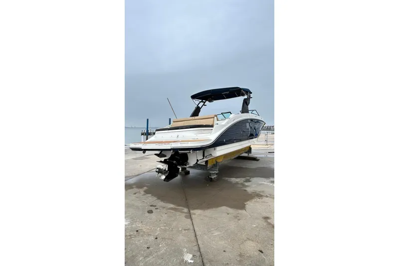 Slide: The Image of 2018 Sea Ray SDX 270 boat on a dock, rear view with overcast sky. - 42