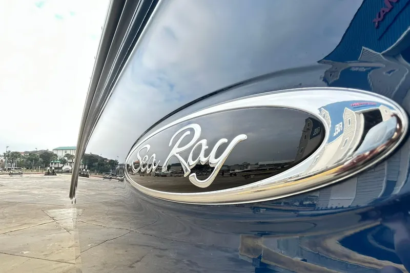 Slide: The Image of 2018 Sea Ray SDX 270 boat emblem with reflective surface in marina setting. - 45