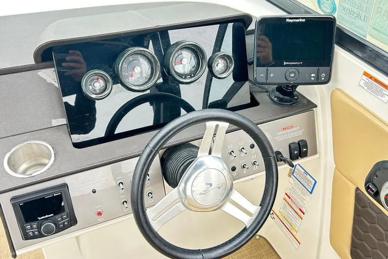 Slide: The Image of 2018 Sea Ray SDX 270 dashboard with steering wheel, gauges, and Raymarine navigation system. - 7