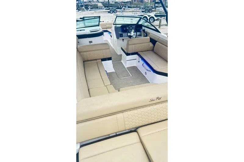 Slide: The Image of Interior of a 2018 Sea Ray SDX 270 boat with beige seating and modern dashboard. - 8
