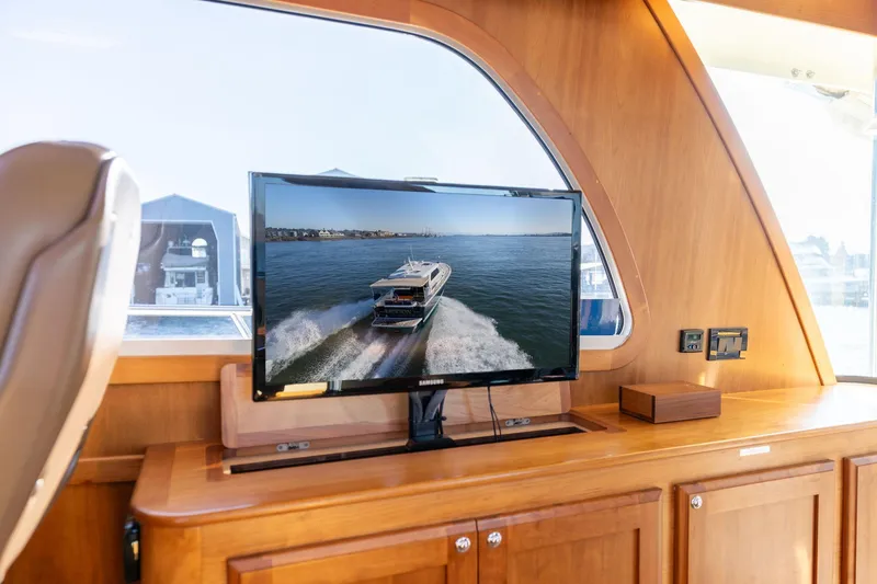 Slide: The Image of Interior of 2013 Sabre 38 Salon Express with TV displaying a boat on water. - 21