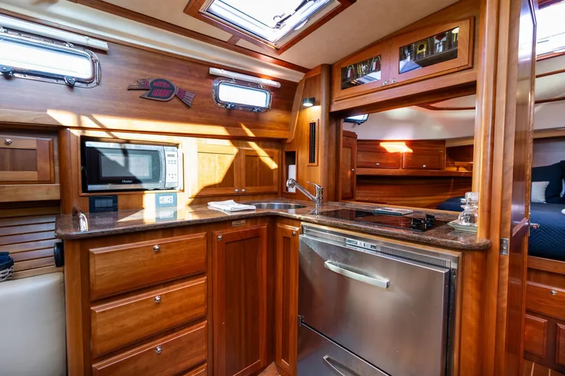 Slide: The Image of Luxurious 2013 Sabre 38 Salon Express yacht interior with wooden cabinetry and modern kitchen amenities. - 27