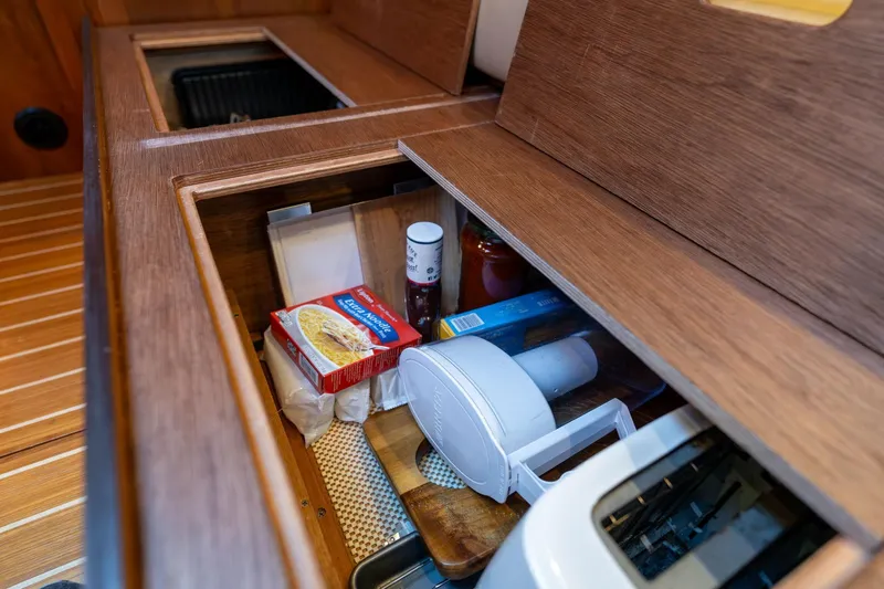 Slide: The Image of Storage compartment in 2013 Sabre 38 Salon Express yacht kitchen with various food items. - 35