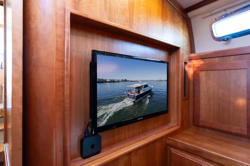 Slide: The Image of Interior of 2013 Sabre 38 Salon Express with TV displaying a boat on water. - 44