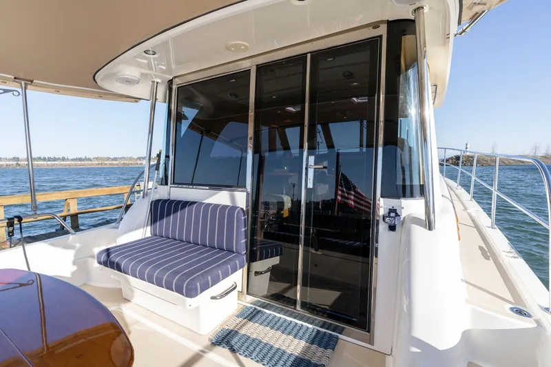 Slide: The Image of 2013 Sabre 38 Salon Express yacht with striped seating and glass doors on deck. - 48