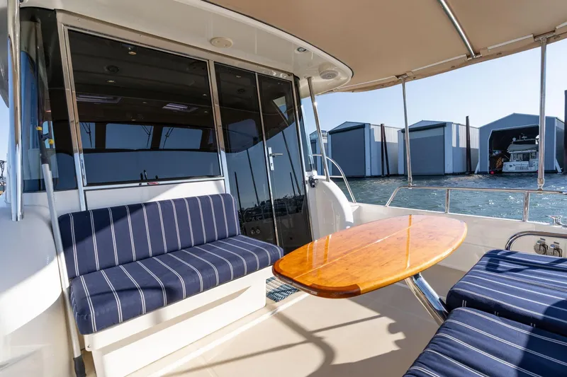 Slide: The Image of 2013 Sabre 38 Salon Express yacht interior with striped seating and wooden table. - 49