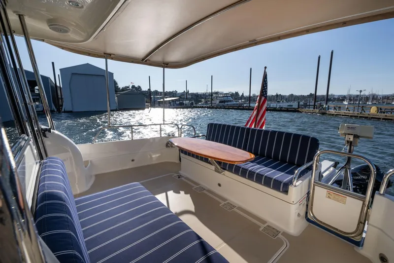 Slide: The Image of 2013 Sabre 38 Salon Express yacht interior with striped seating and marina view. - 51