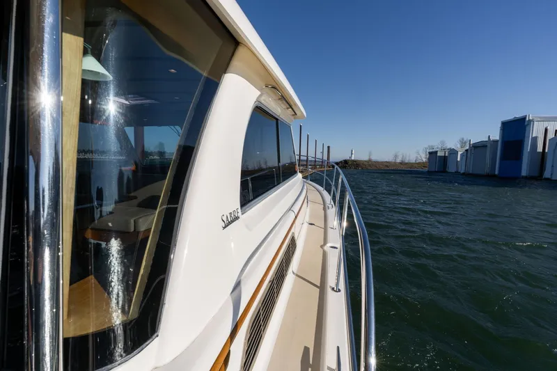 Slide: The Image of 2013 Sabre 38 Salon Express yacht on water, sunny day, marina in background. - 52