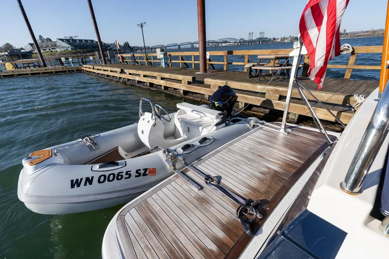 Slide: The Image of 2013 Sabre 38 Salon Express docked with inflatable boat, American flag visible. - 60
