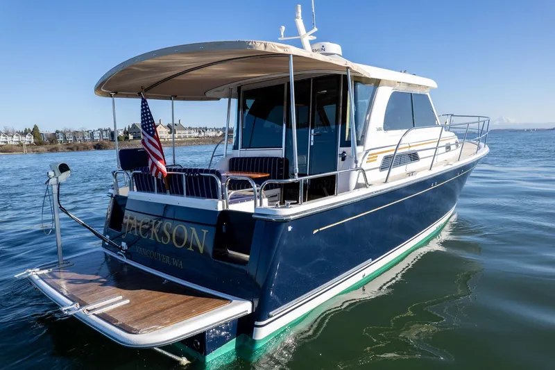 Slide: The Image of 2013 Sabre 38 Salon Express yacht on calm water, rear view with American flag. - 63