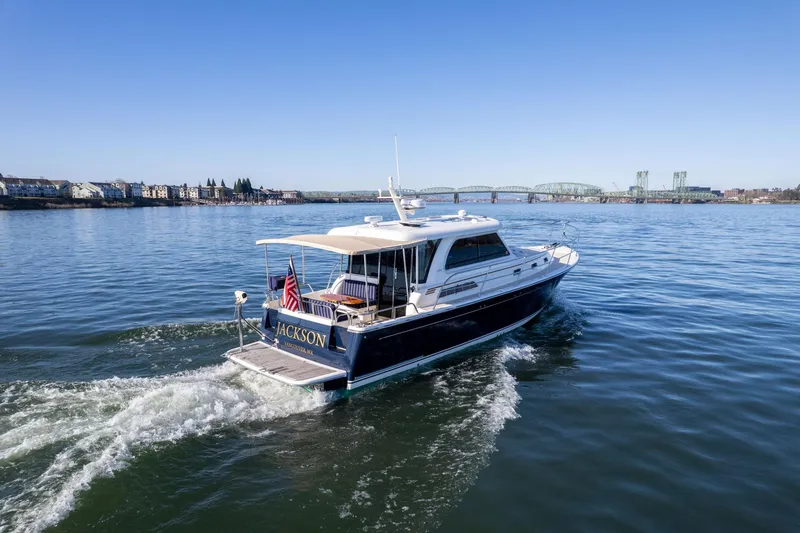 Slide: The Image of 2013 Sabre 38 Salon Express yacht cruising on a calm river with a bridge in the background. - 65