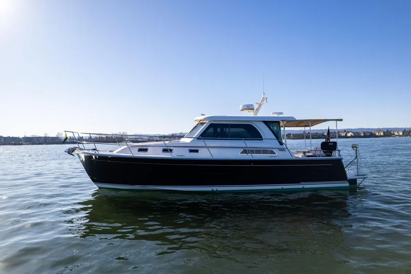 Slide: The Image of 2013 Sabre 38 Salon Express yacht on calm water under clear blue sky. - 66
