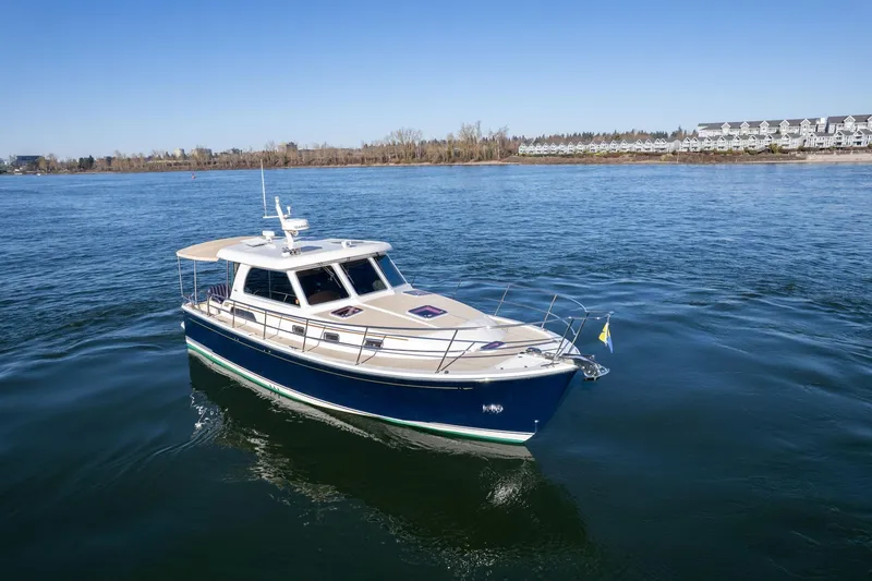 Slide: The Image of 2013 Sabre 38 Salon Express yacht cruising on a calm river near a residential area. - 68