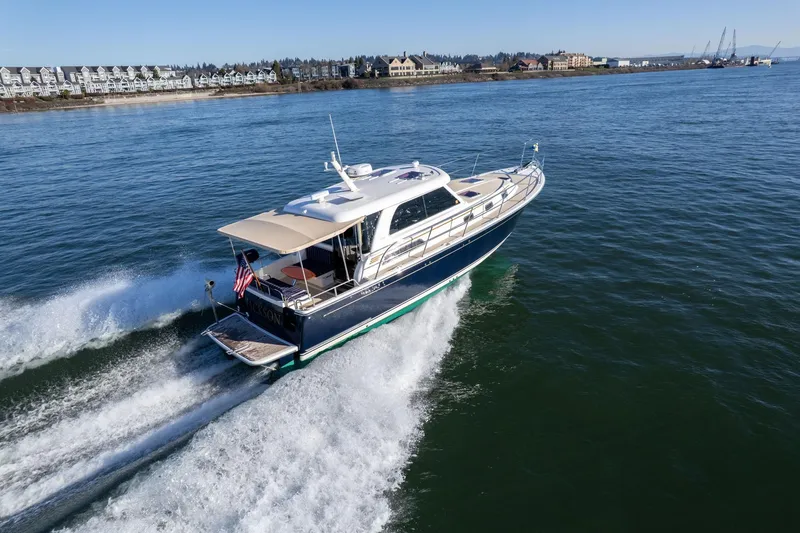 Slide: The Image of 2013 Sabre 38 Salon Express cruising on open water, near coastal buildings. - 74