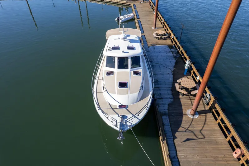 Slide: The Image of 2013 Sabre 38 Salon Express yacht docked at a wooden pier on calm water. - 82