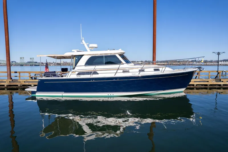 Slide: The Image of 2013 Sabre 38 Salon Express yacht docked on calm water under clear blue sky. - 84