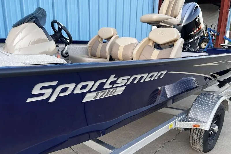 Slide: The Image of 2023 G3 Sportsman 1710 boat with beige seats and blue exterior on a trailer. - 3