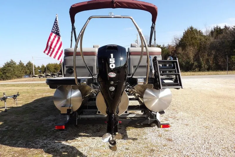 Slide: The Image of 2026 Bennington M Quad Bench 22 MFB pontoon boat with outboard motor and American flag. - 10