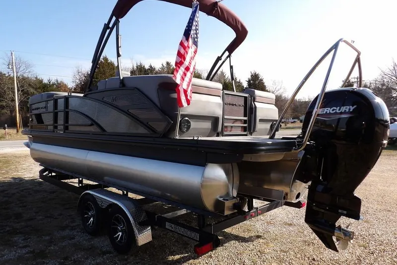 Slide: The Image of 2026 Bennington M Quad Bench 22 MFB pontoon boat with Mercury engine and American flag. - 3
