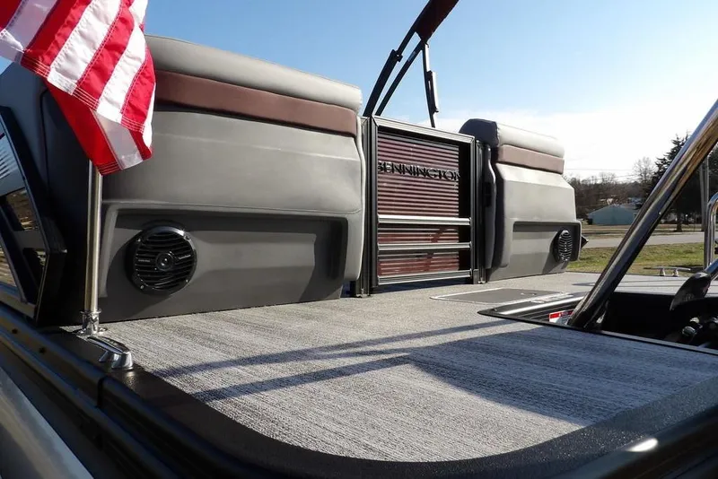 Slide: The Image of 2026 Bennington M Quad Bench 22 MFB pontoon boat with American flag and sleek design. - 39