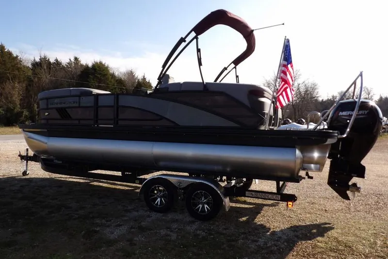 Slide: The Image of 2026 Bennington M Quad Bench 22 MFB pontoon boat on trailer with American flag. - 5