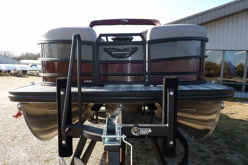 Slide: The Image of 2026 Bennington M Quad Bench 22 MFB pontoon boat on trailer, outdoor setting. - 6