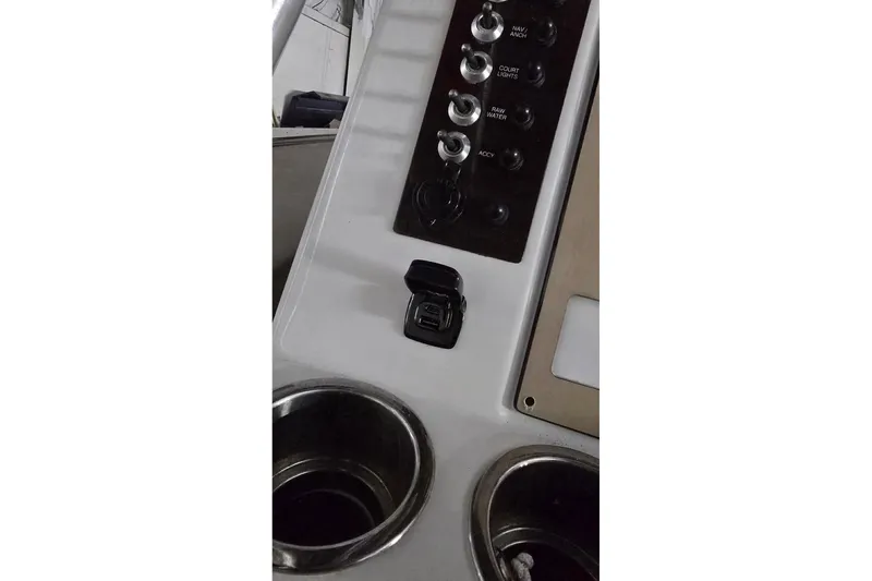 Slide: The Image of 2017 Robalo R200ES boat dashboard with switches and cup holders. - 13