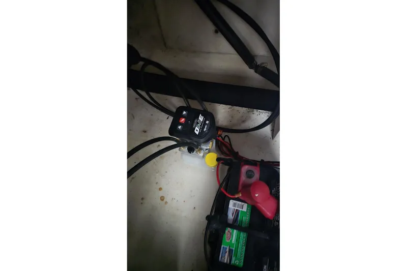 Slide: The Image of 2017 Robalo R200ES boat battery compartment with wiring and connections. - 14