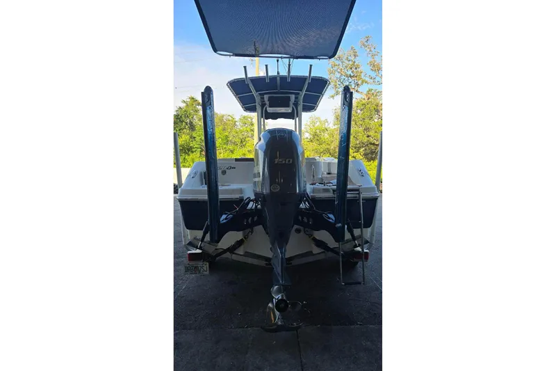 Slide: The Image of 2017 Robalo R200ES boat with Yamaha 150 engine, parked under a canopy. - 3