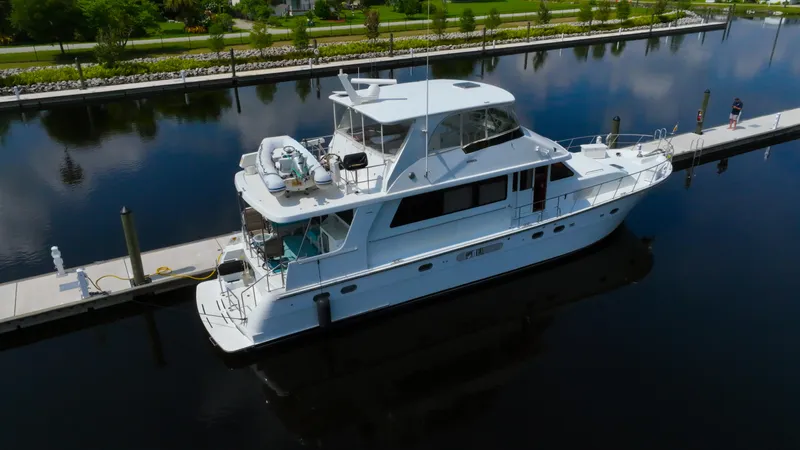 Slide: The Image of 2005 Jefferson Marquessa 60 MY yacht docked in a serene marina setting. - 2